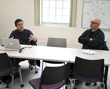 two men at a table talking