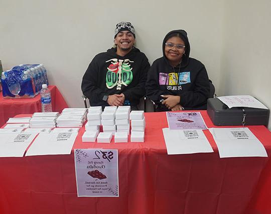 two people sitting at a table, smiling